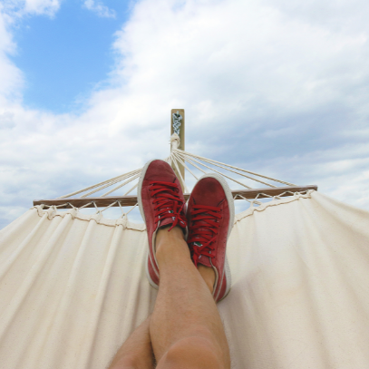 person wearing red shoes laying in a hammock image