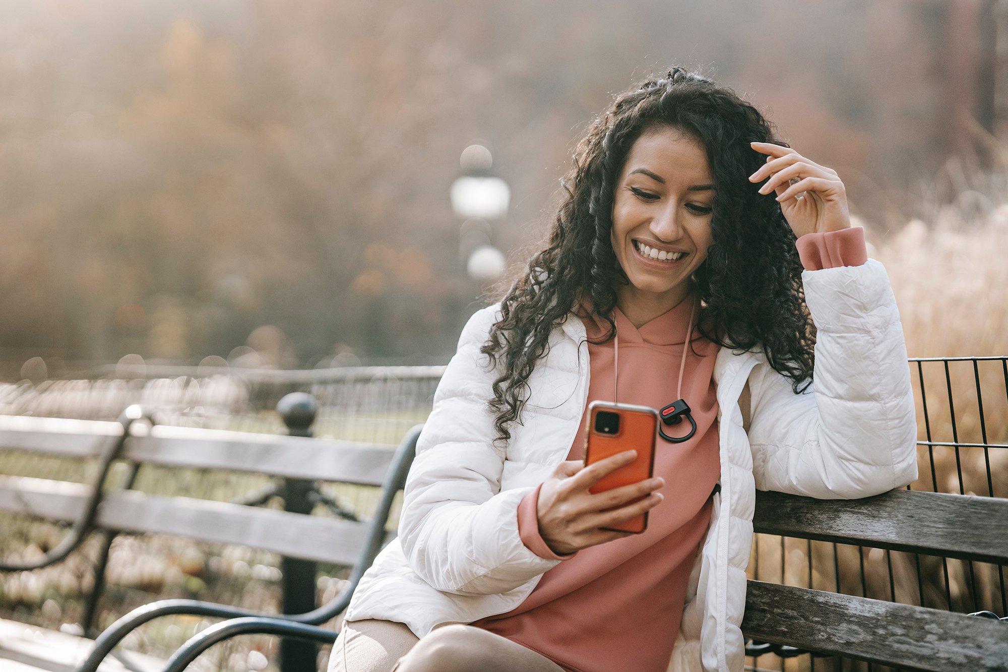 woman using smart phone sitting on a bench image