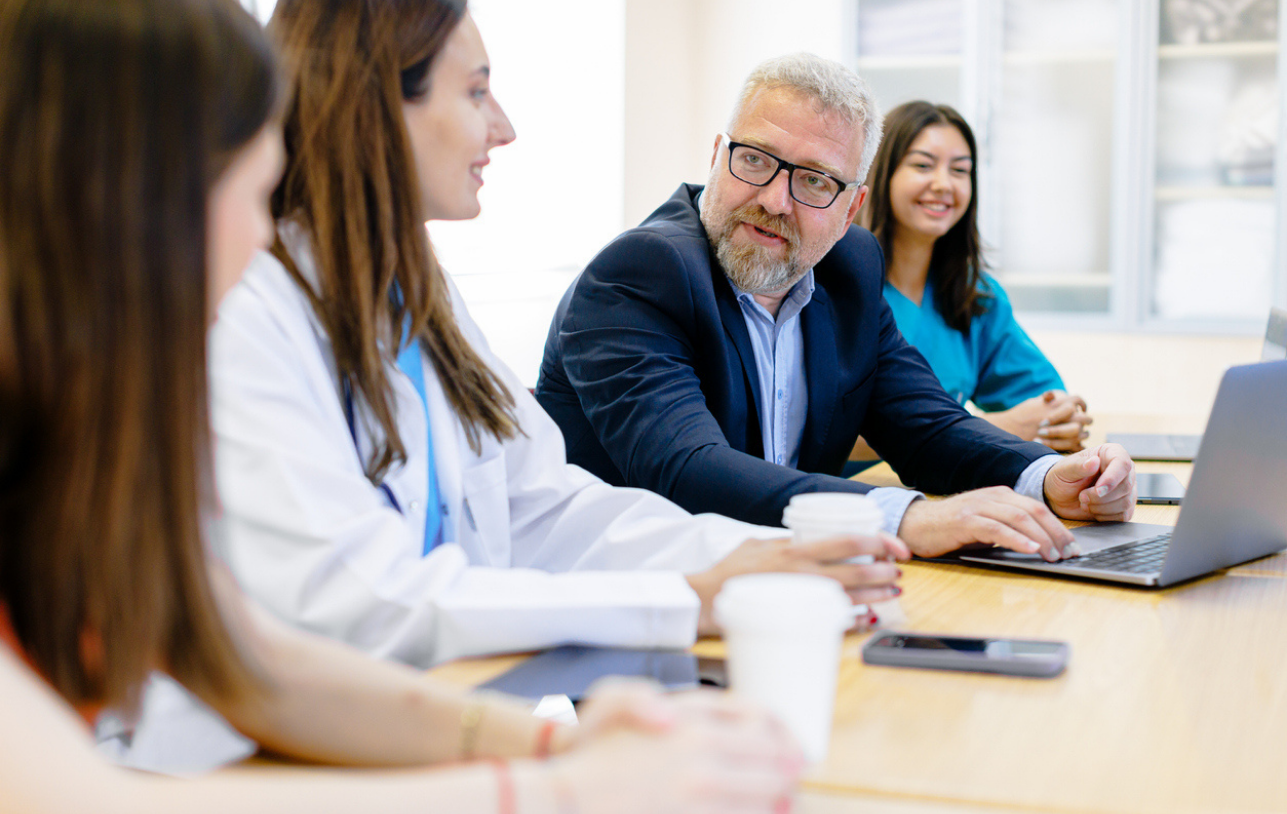 A doctor speaking to a room full of nurses. 