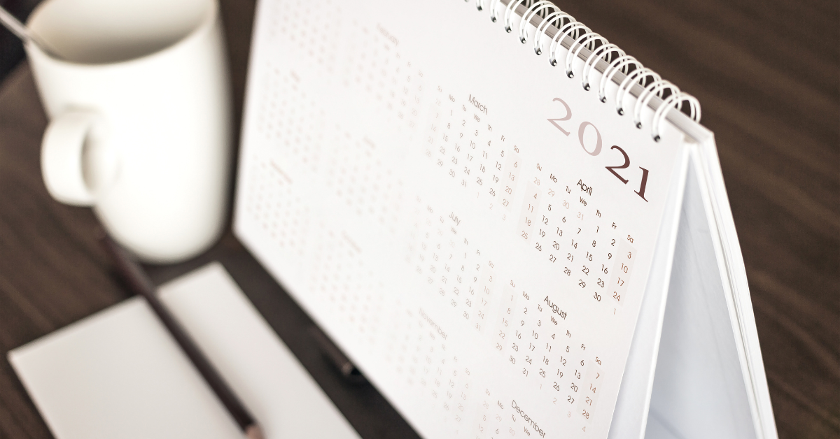 2021 calendar next to a coffee mug on a wooden table image