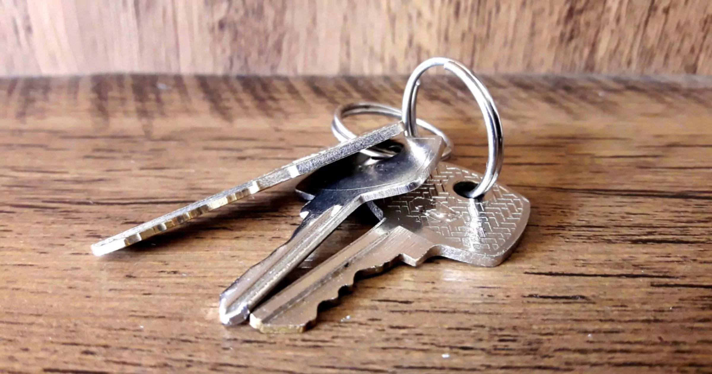 three keys on a wooden table