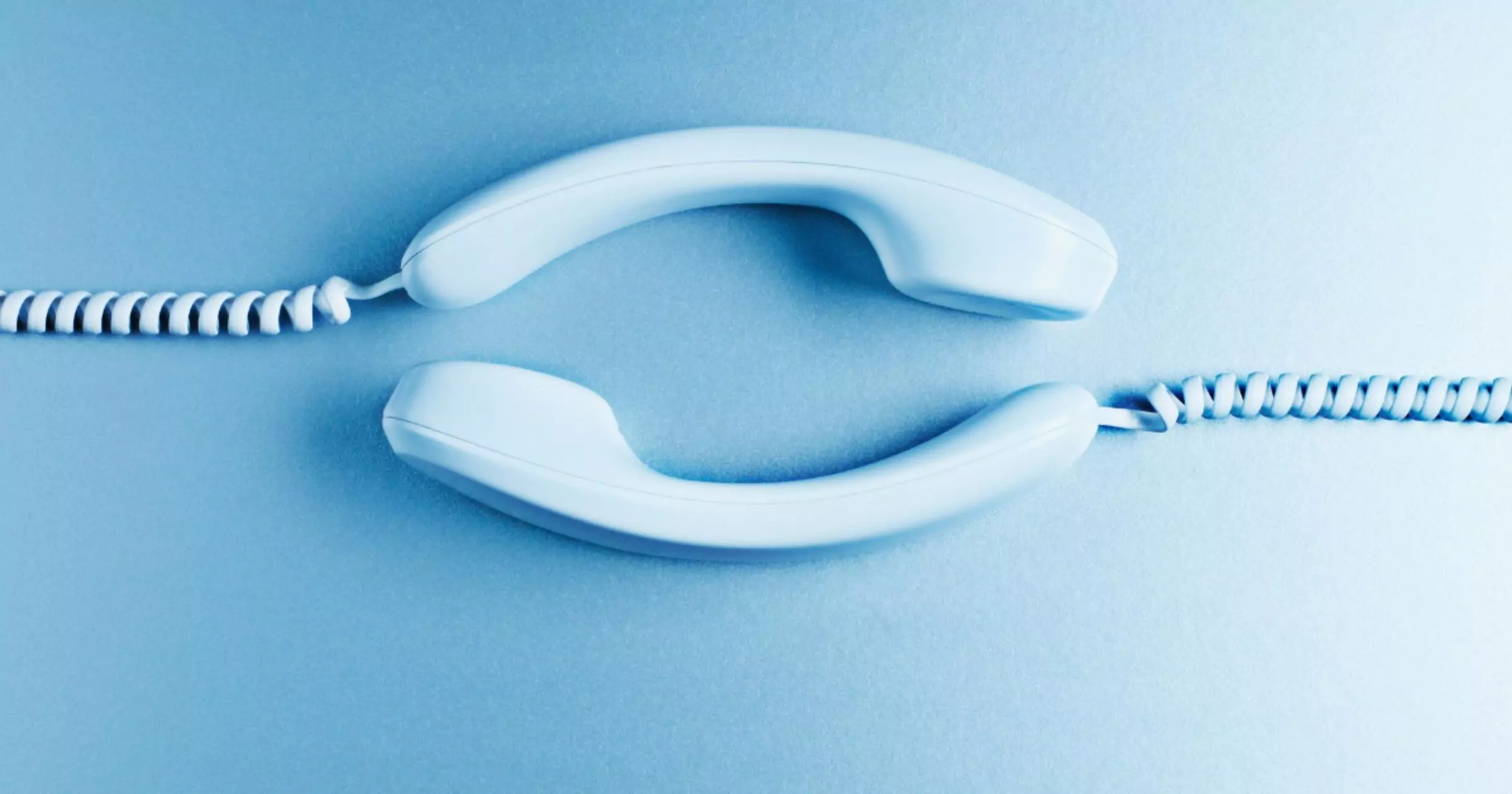 two telephones laying on a blue surface