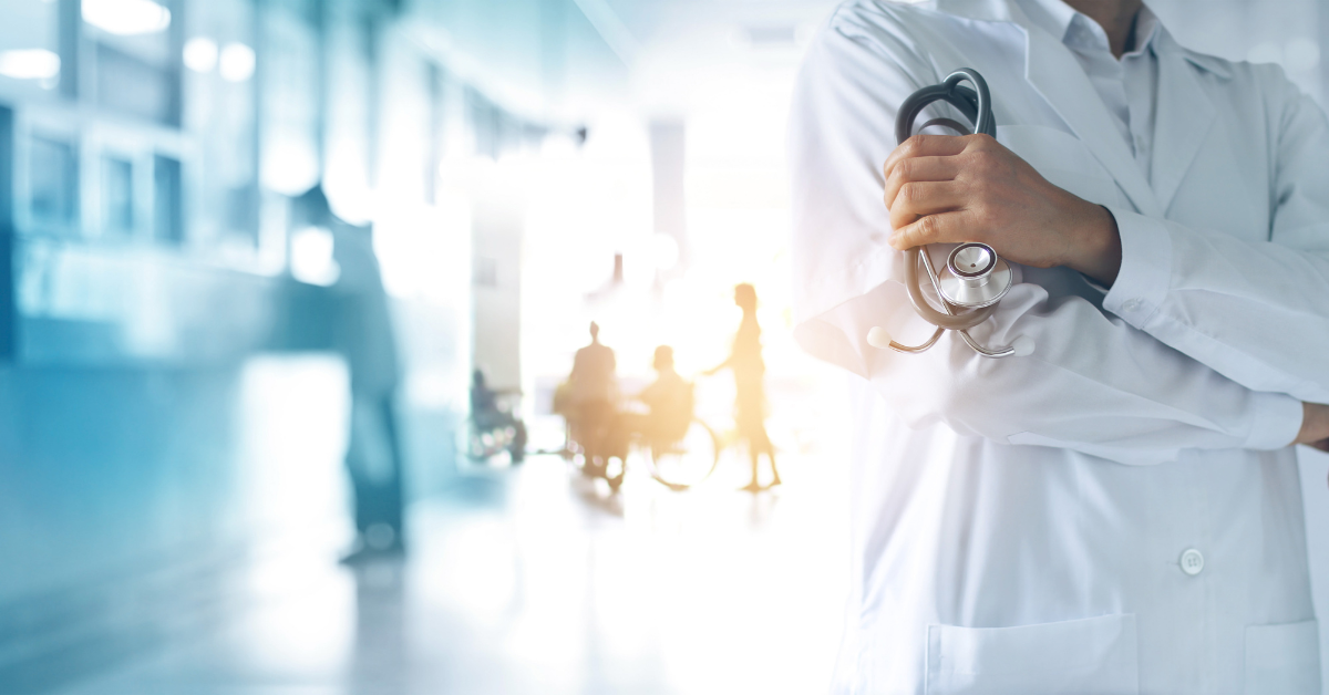 doctor holding a stethoscope in hand and patients are seen in the hospital background image