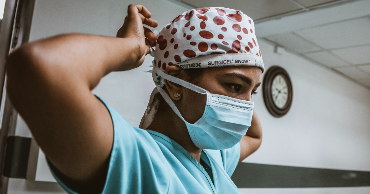 female nurse wearing face mask and scrub cap
