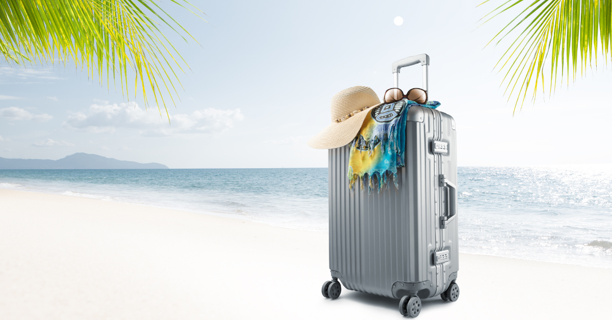 suitcase with hat and sunglasses on a beach image