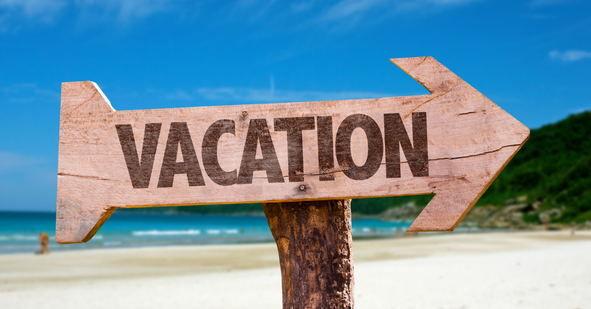 wooden vacation sign on a beach